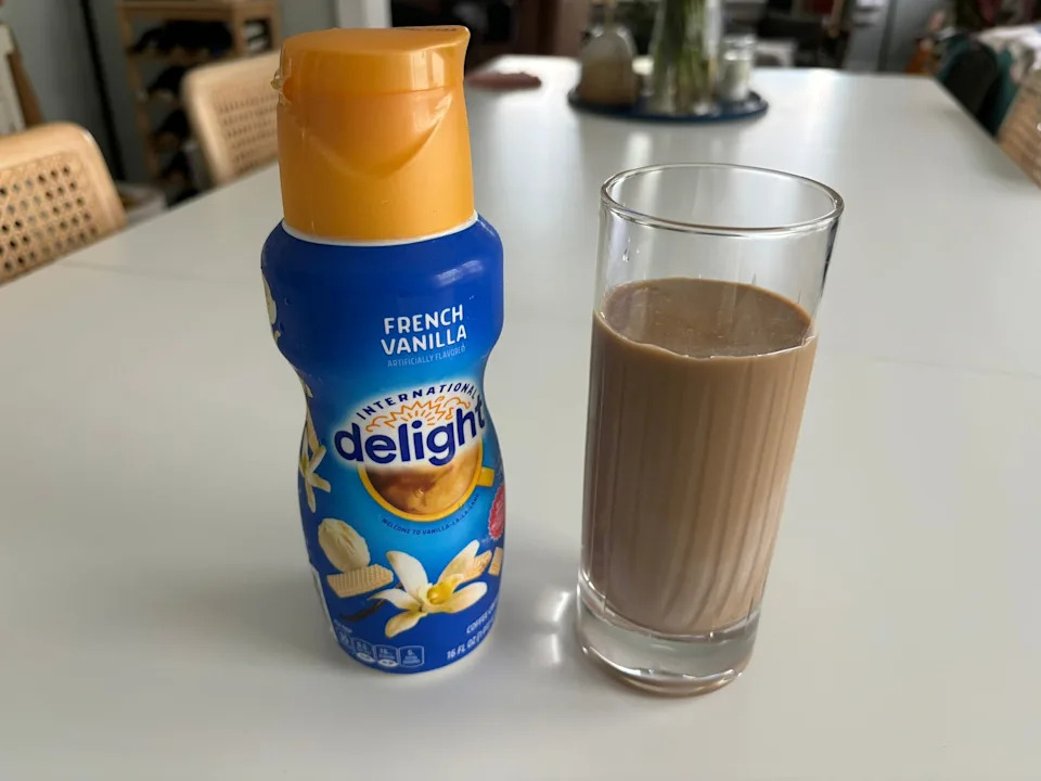 International delight french vanilla creamer next to glass of coffee with cream in it