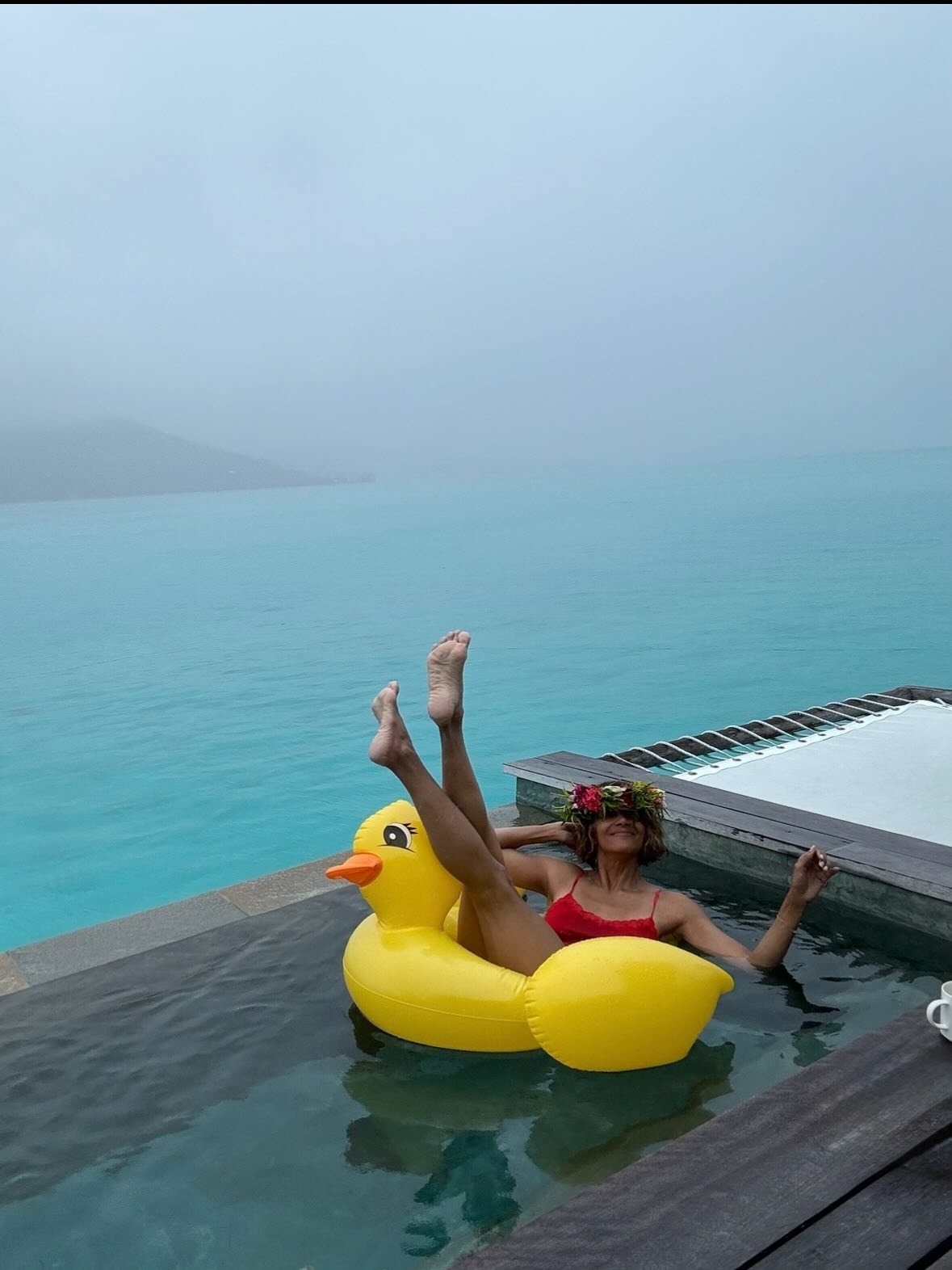 Halle Berry lässt sie nicht von einem bewölkten Tag nach unten bringen, während sie sich auf einem Entenschwimmer im Pool schauscht.