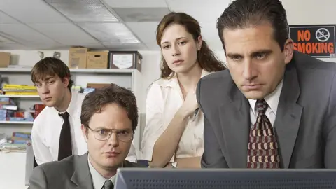 Getty Images (LR) John Krasinski als Jim Halpert, Raine Wilson als Dwight Schrute, Jenna Fischer als Pam Beesly und Steve Carell als Michael Scott im Jahr 2004 während des Piloten des Amtes