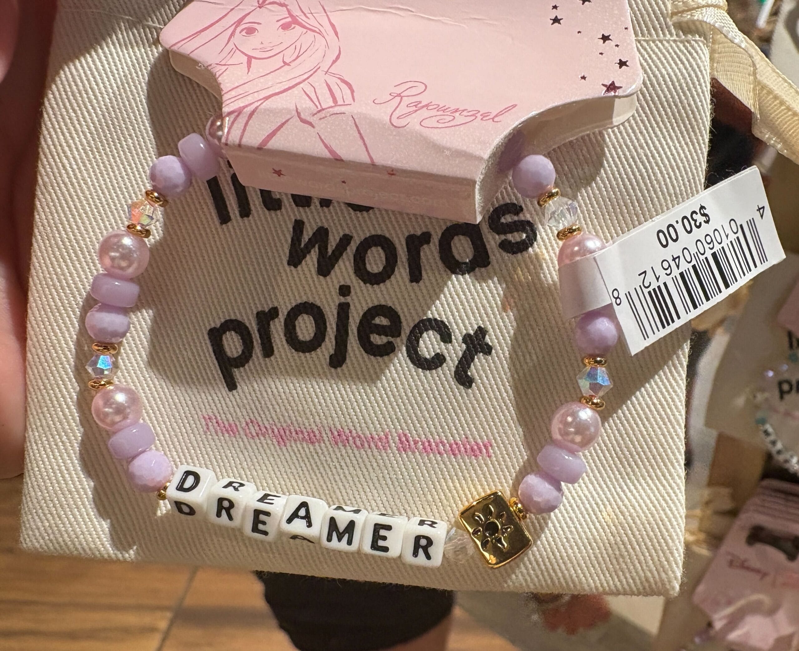 Ein Perlenarmband mit „Dreamer“ -Schestellungen, die auf Rapunzel-Thema ausgestellt sind "Little Words Project" Verpackung.
