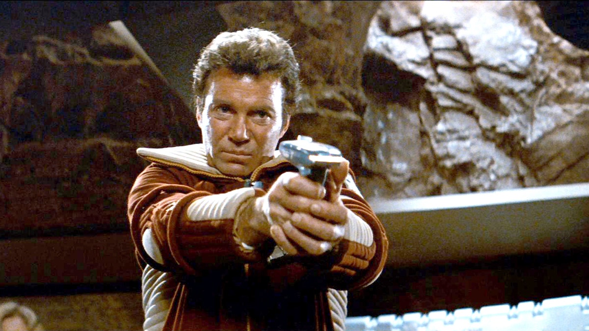 William Shatner hält eine Waffe in einer Szene von Star Trek ab
